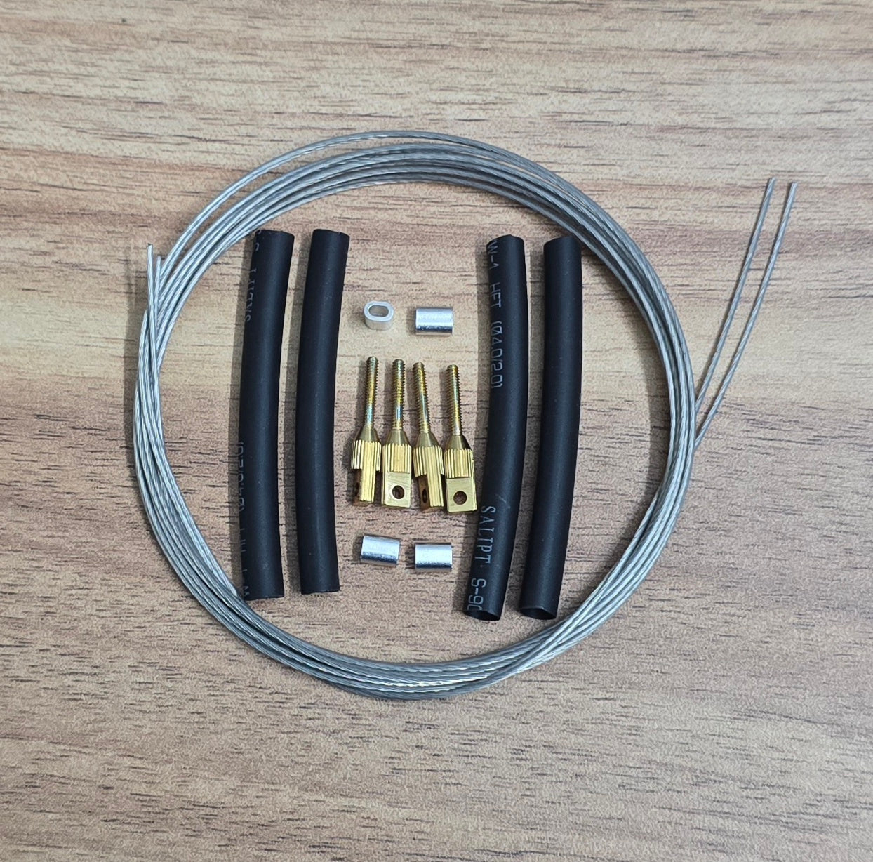 Set of aircraft control cables and components on a wooden surface