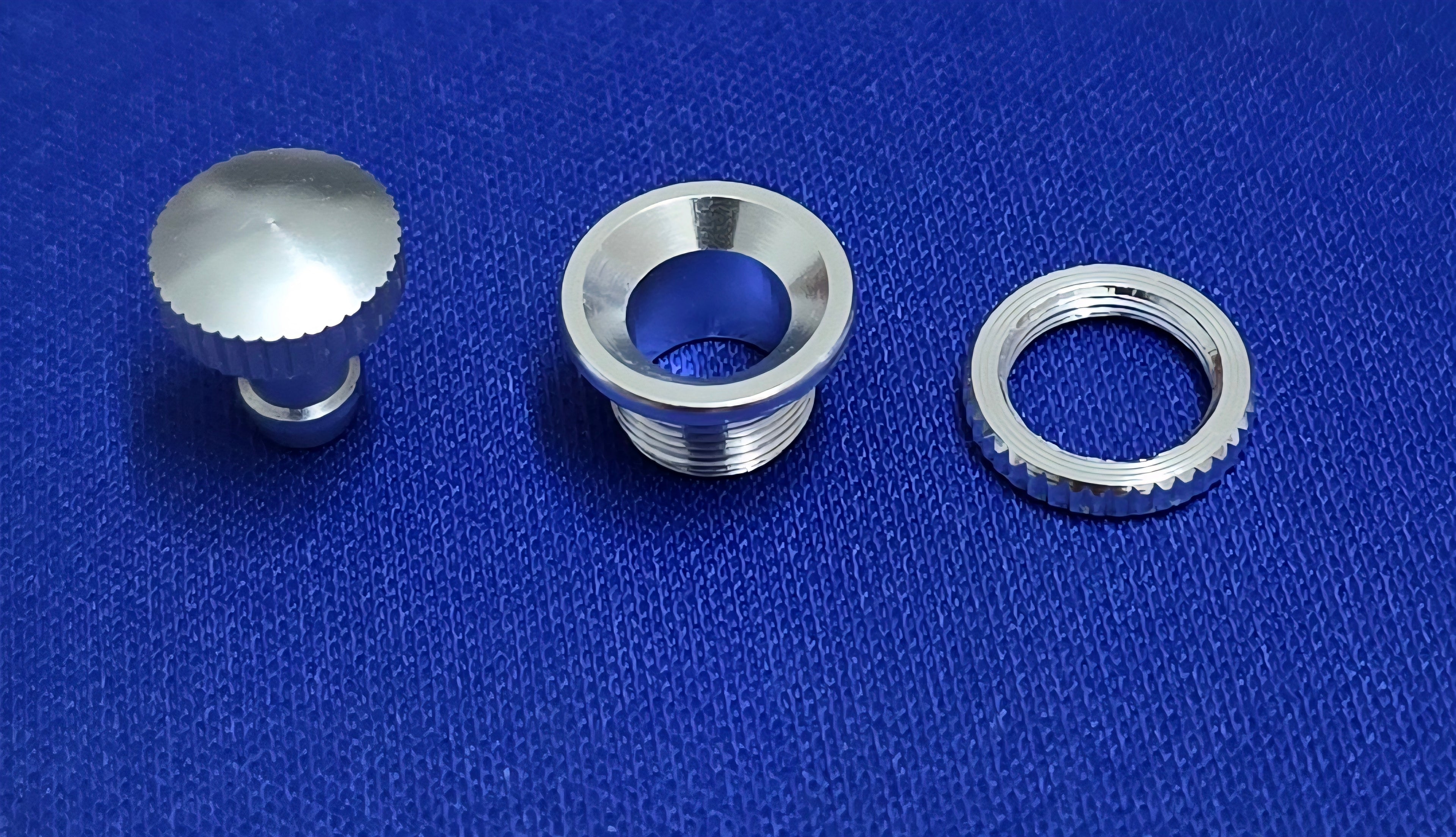 Three metallic components of Fuel Dot AeroNautical on a blue textured background.