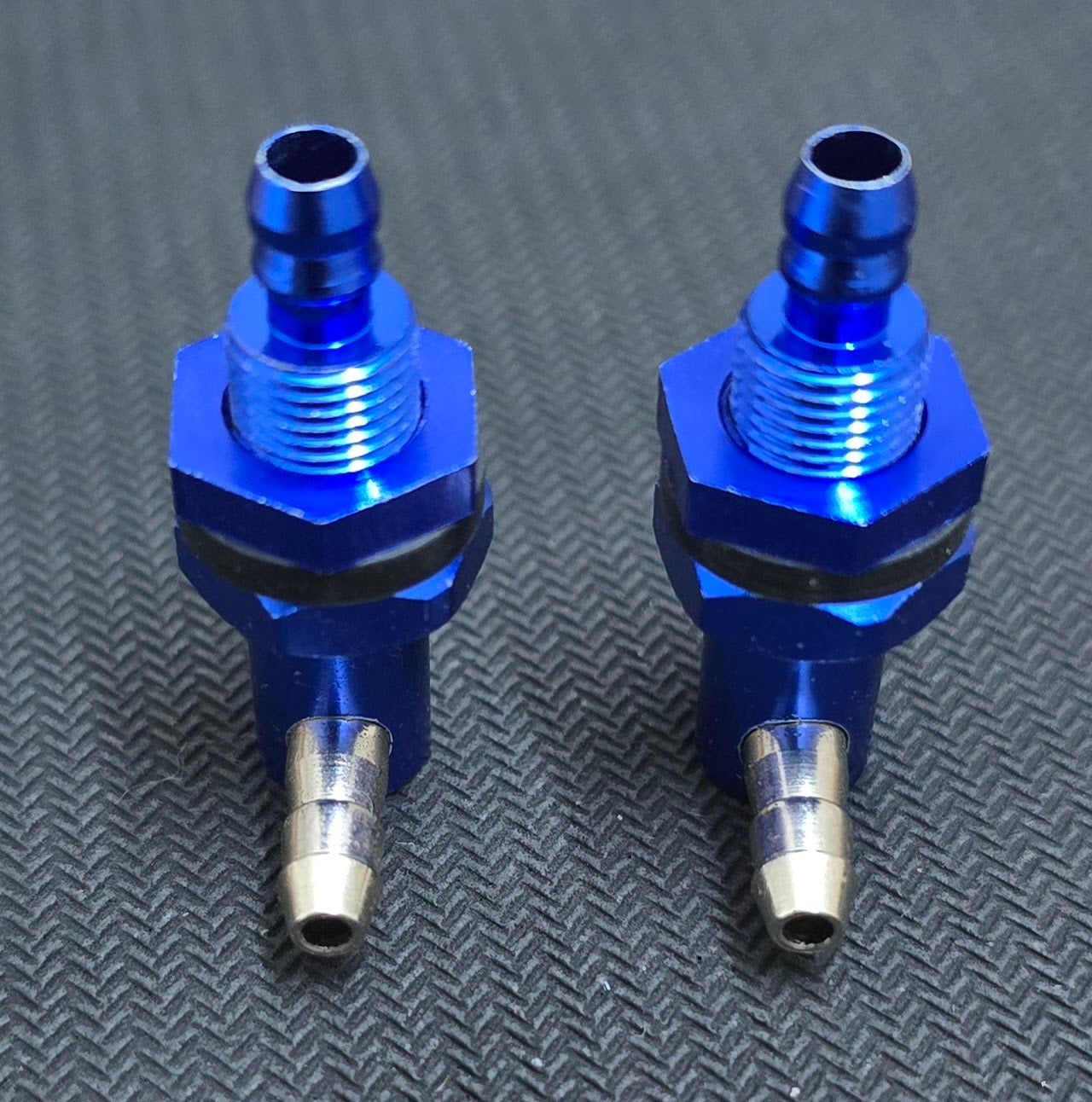 Two blue metal fittings on a textured gray background