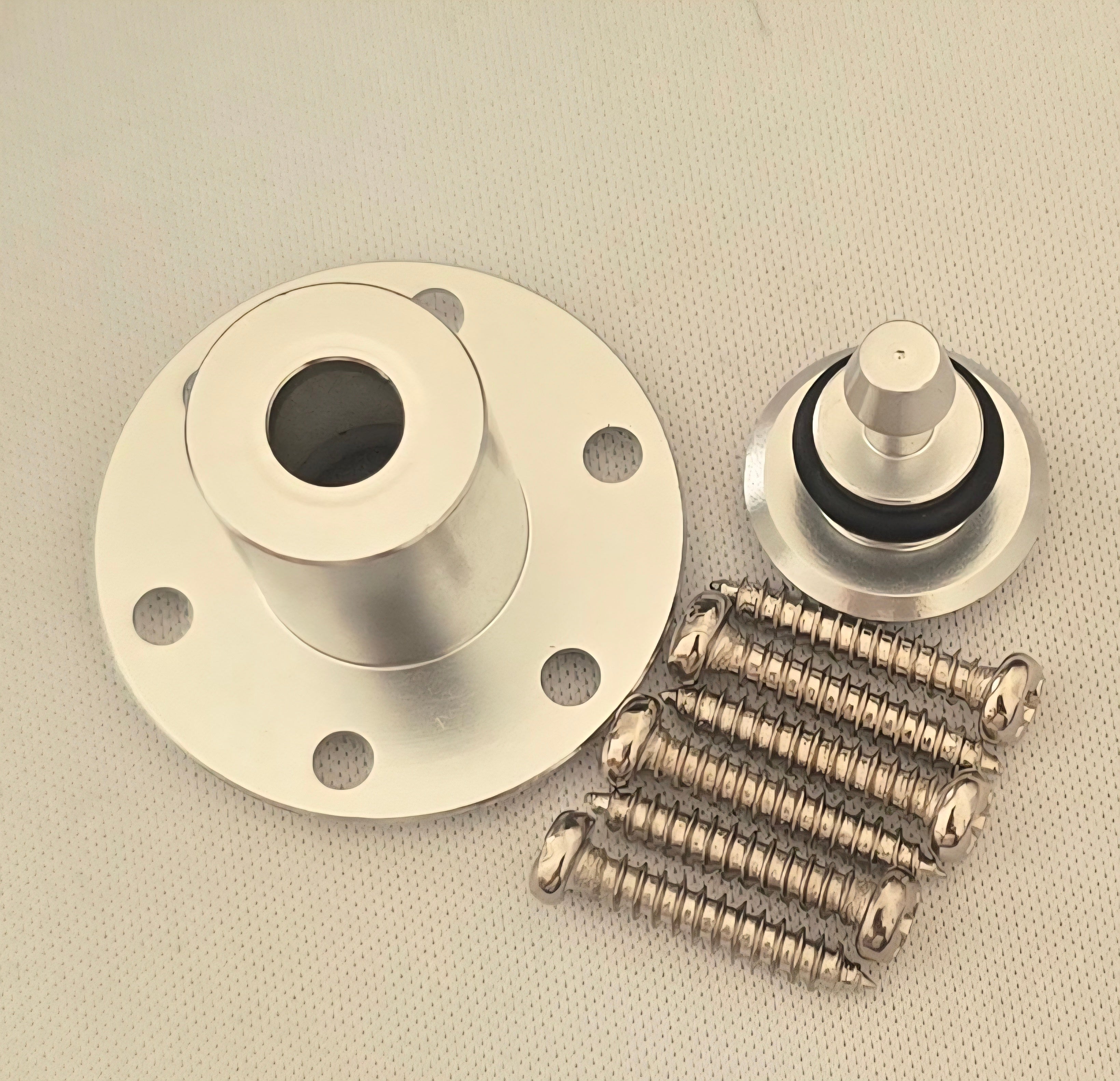 Metal components including a flange, two cylindrical parts, and springs on a beige background