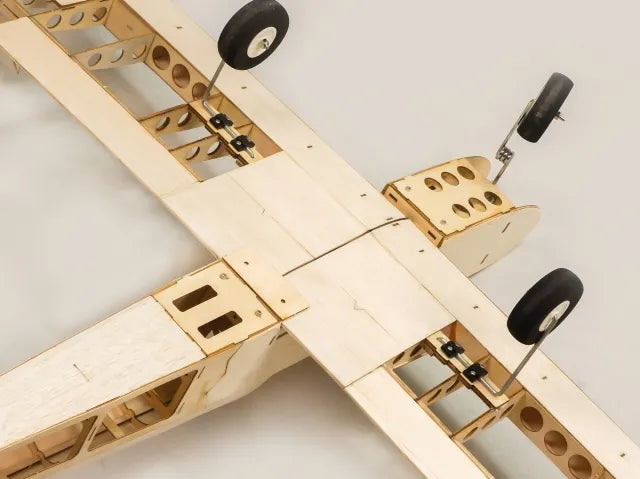 Wooden model airplane with wheels on a white background