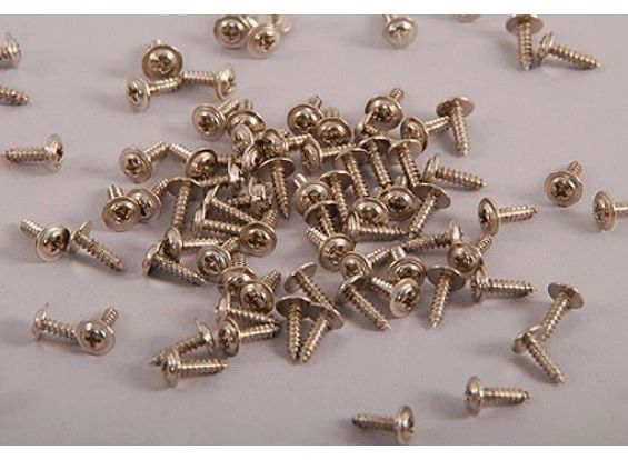 Collection of brass screws on a light gray background